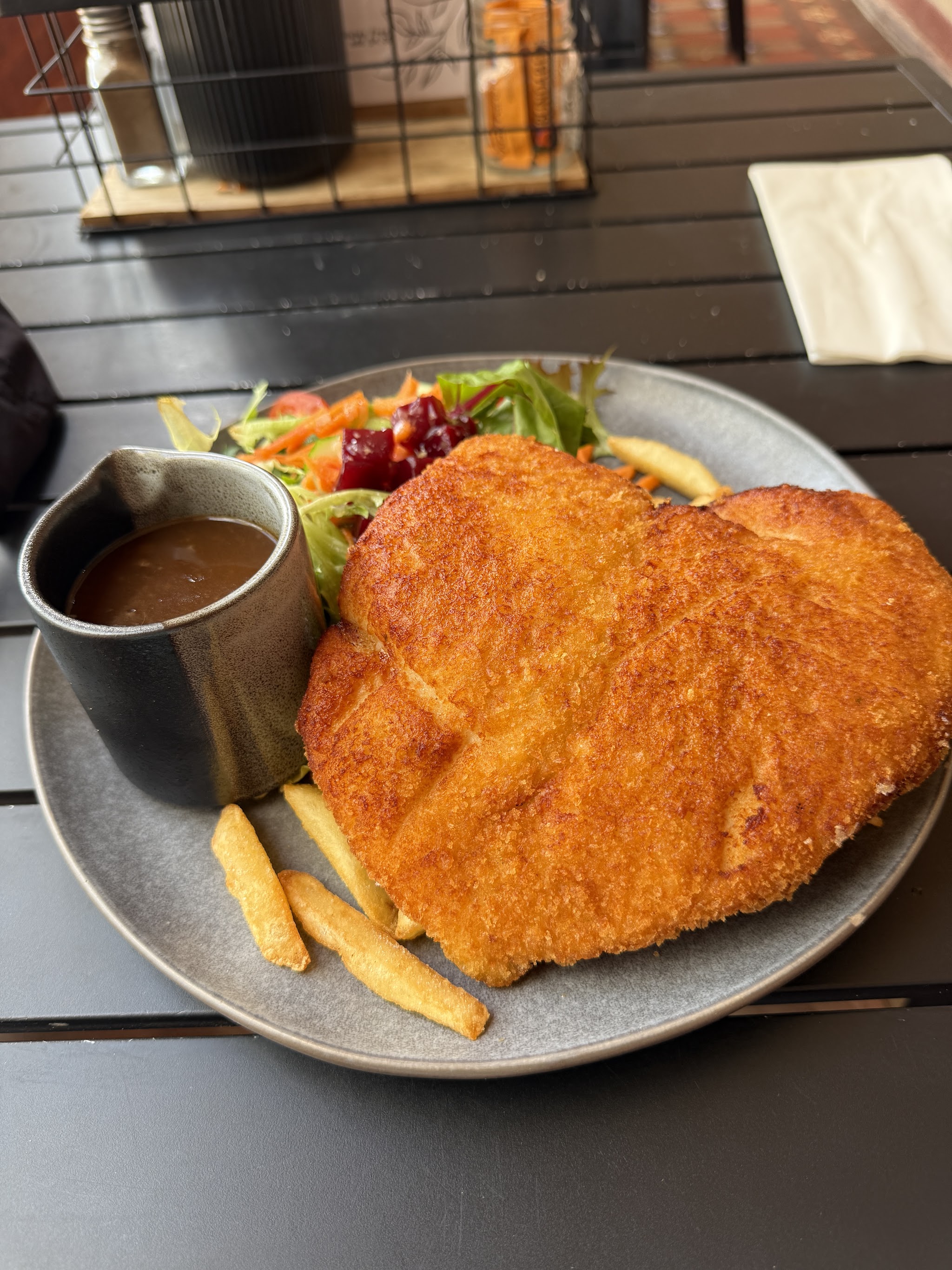 Chicken schnitzel with a jug of gravy, chips and a garden salad